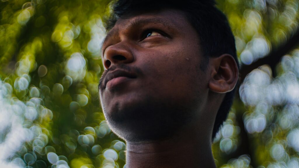 Close-up portrait of a man outdoors with a bright bokeh background captured in TN, India.